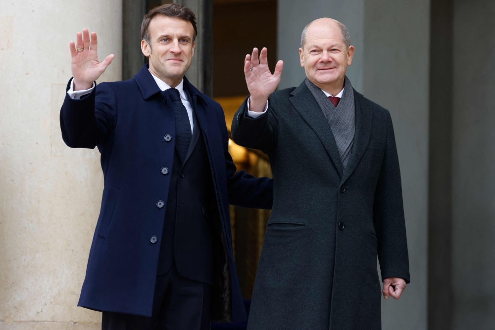 France’s President Emmanuel Macron (left) and German Chancellor Olaf Scholz (right) wave as they arrive to attend a cabinet meeting, as part of the celebration of the 60th anniversary of the signing of the Elysee Treaty, to seal reconciliation between France and West Germany, 18 years after the Second World War at the presidential Elysee Palace in Paris on January 22, 2023. ― AFP pic