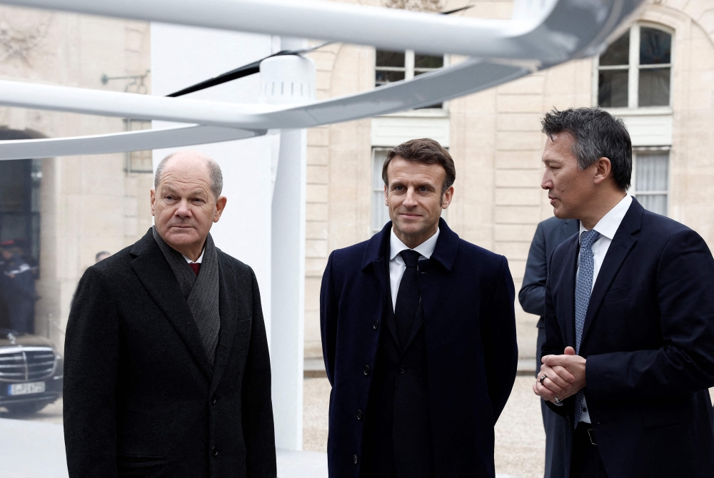 France’s President Emmanuel Macron (centre) and German Chancellor Olaf Scholz (left) listen to explanations during a joint cabinet meeting presenting Franco-German industrial projects, as part of the celebration of the 60th anniversary of the signing of the Elysee Treaty, to seal reconciliation between France and West Germany, 18 years after the Second World War at the presidential Elysee Palace in Paris on January 22, 2023. ― AFP pic