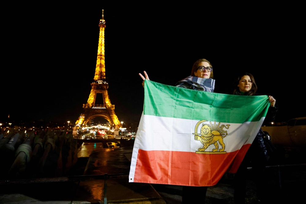 File photo of protesters holding Iran’s former flag on the Trocadero Esplanade Trocadero Esplanade during an event to display the slogan ‘Woman. Life. Freedom.’ on the Eiffel Tower, in a show of support to the Iranian people, in the wake of the death of young Iranian woman Masha Amini who died in the country's morality police custody, in Paris, on January 16, 2023. ― AFP pic