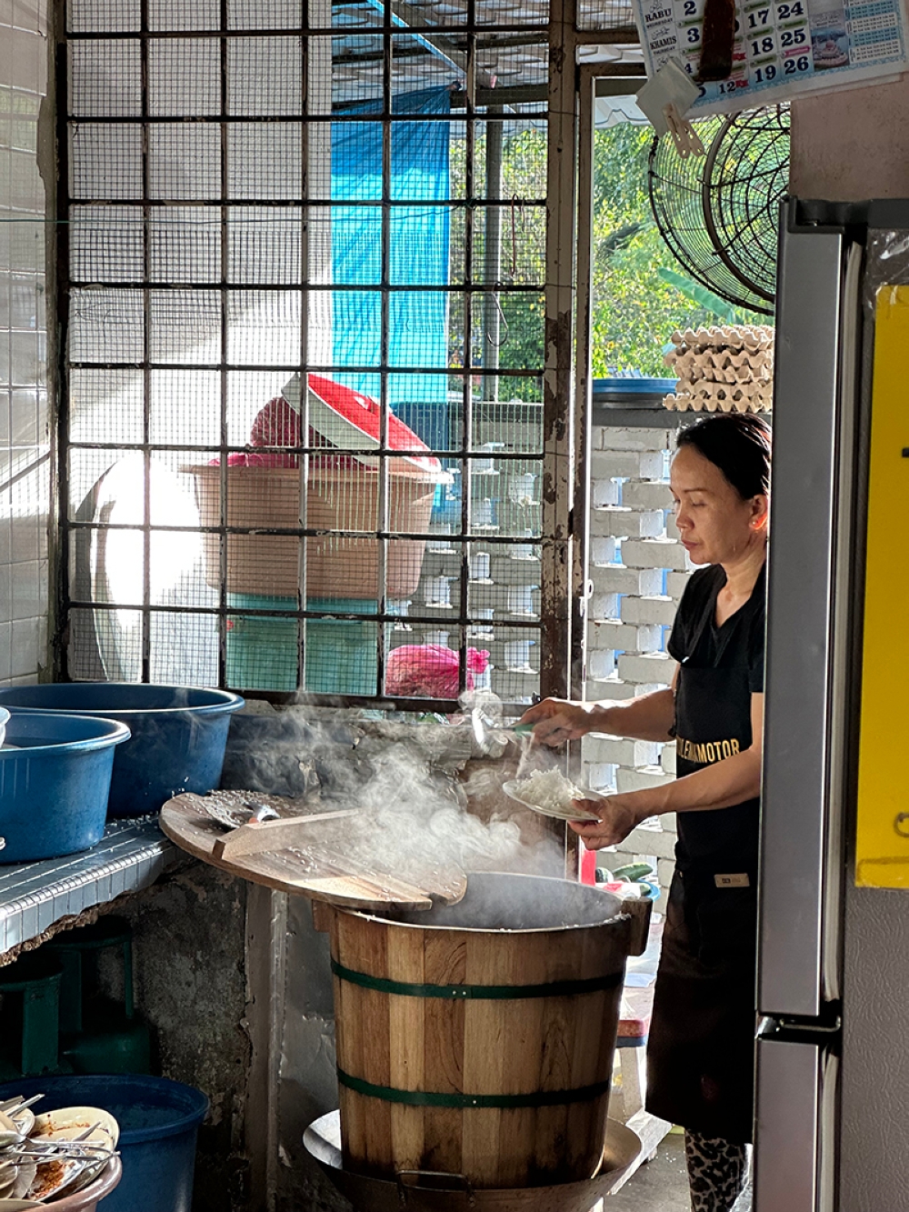 Fluffy rice with a light coconut milk taste is cooked in a traditional wooden bucket