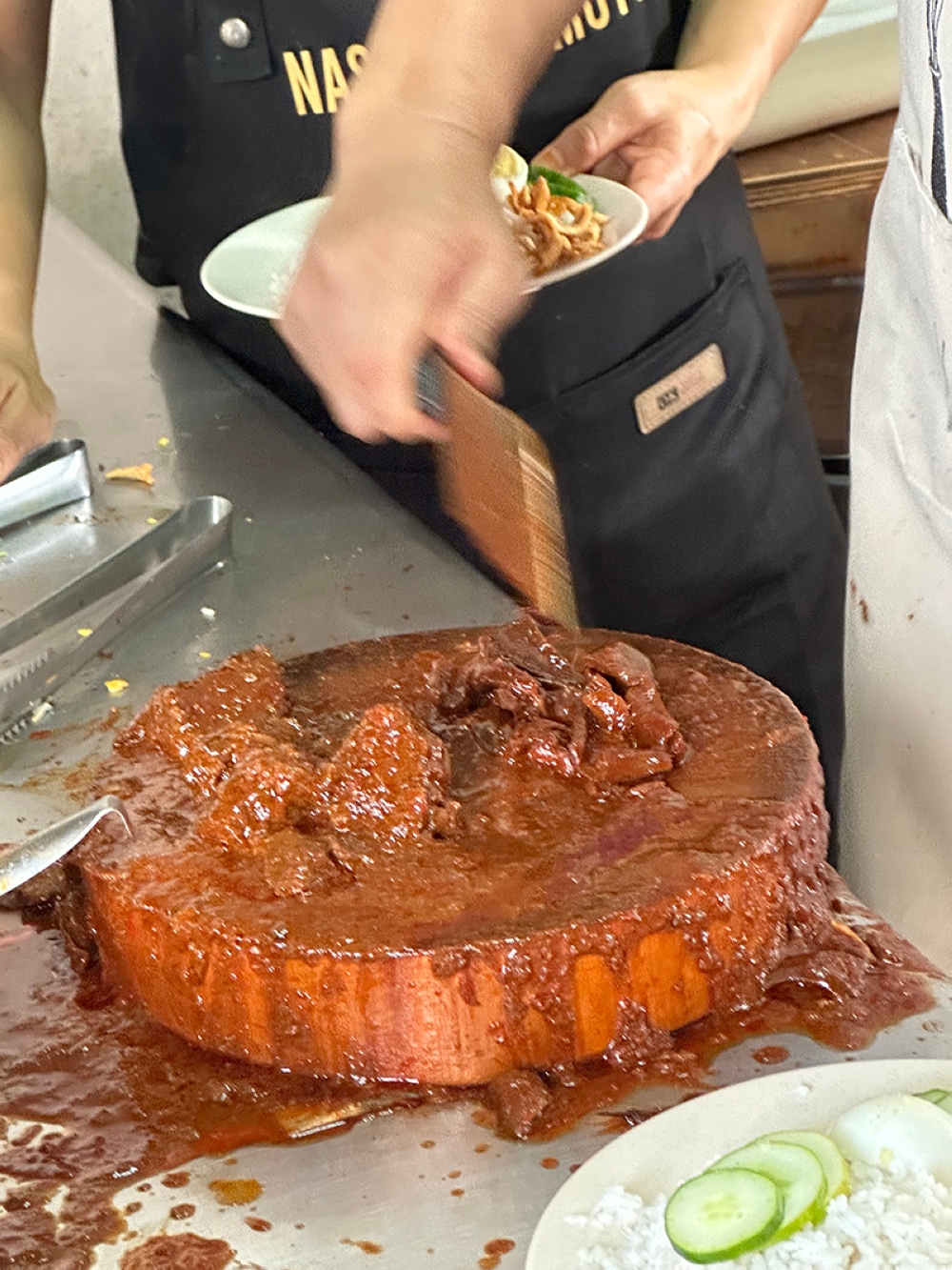 The meat or 'sotong' is cut into pieces before it's placed on top of the hot fluffy rice