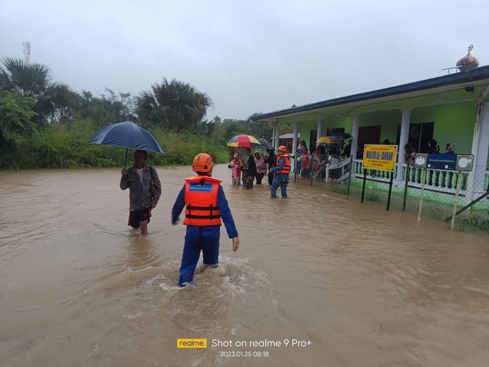 Malaysia Civil Defence Force members assist a family at their flood-hit home in Kota Marudu. — Picture via Facebook/APM Kota Marudu