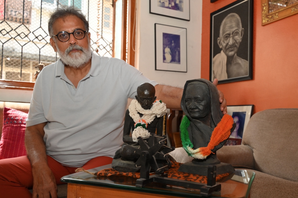 In this picture taken on January 25, 2023, Indian author Tushar Gandhi, who is the great-grandson of Mahatma Gandhi, poses for  a picture next to a bust of his great-grandfather during an interview at his home in Mumbai. — AFP pic