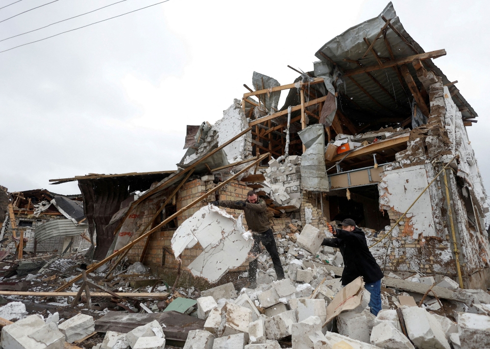 Local residents remove debris from a house of their  neighbour damaged by a Russian military strike, amid Russia's attack on Ukraine, in the town of Hlevakha, outside Kyiv, Ukraine January 26, 2023. — Reuters pic