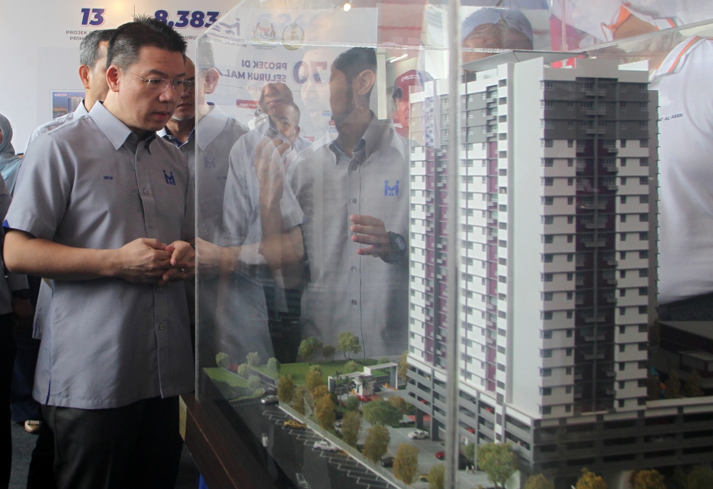 Local Government Development Minister Nga Kor Ming (left) looking at the architectural model of the Kepayang Residency during the key handover ceremony, Ipoh, January 28, 2023. — Bernama pic
