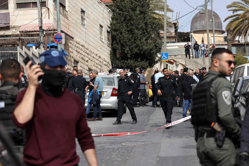 Members of the Israeli security forces stand guard at a cordoned-off area in east Jerusalem’s predominantly Arab neighbourhood of Silwan, where an assailant reportedly shot and wounded two people, on January 28, 2023. — AFP pic