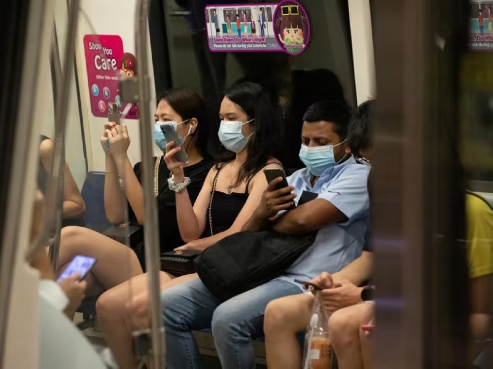 Passengers wearing face masks in an MRT train in Singapore. ― TODAY pic