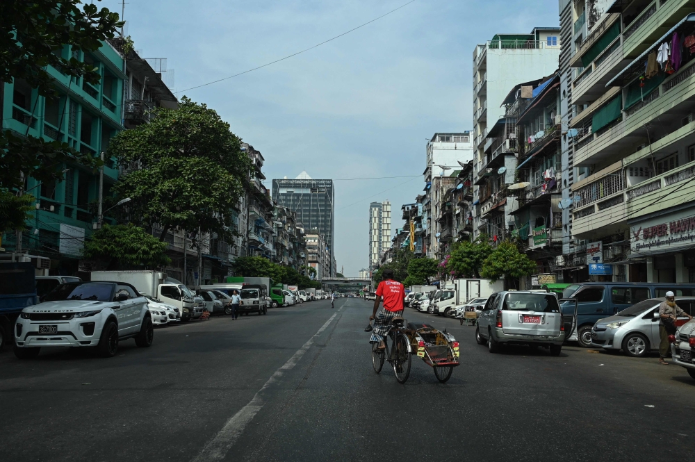 A man rides his trishaw an almost empty street during a 