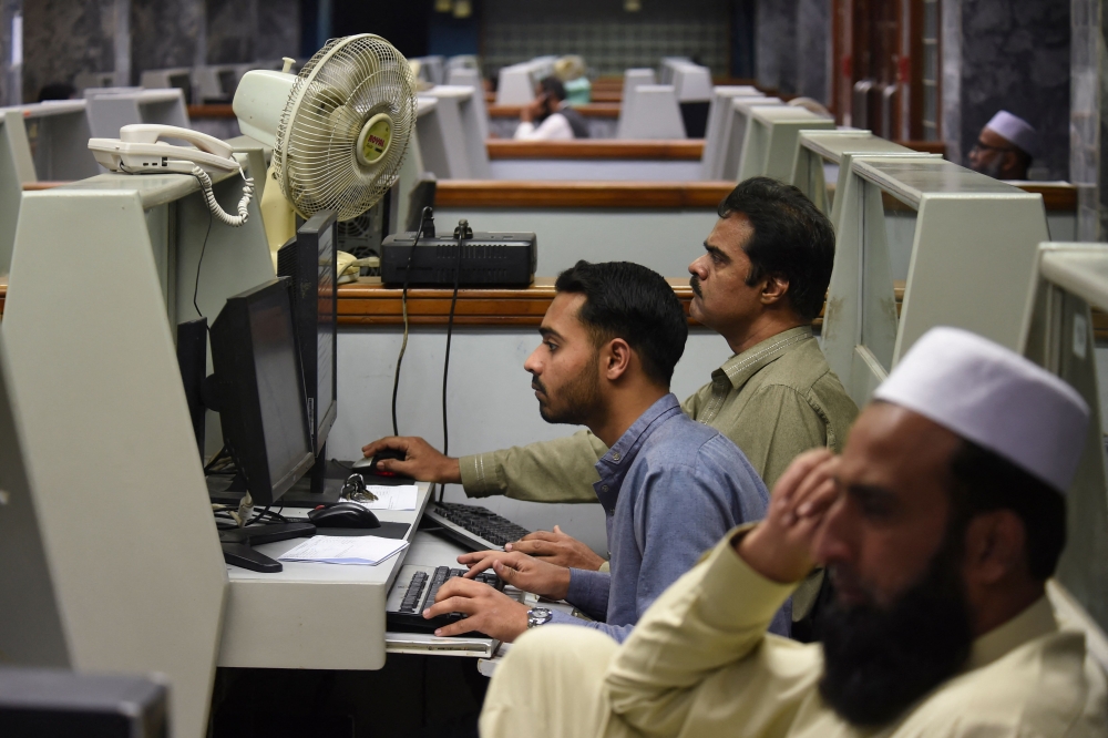 Stockbrokers look at the latest share prices at the Pakistan Stock Exchange in Karachi on February 3, 2023. ― Reuters pic