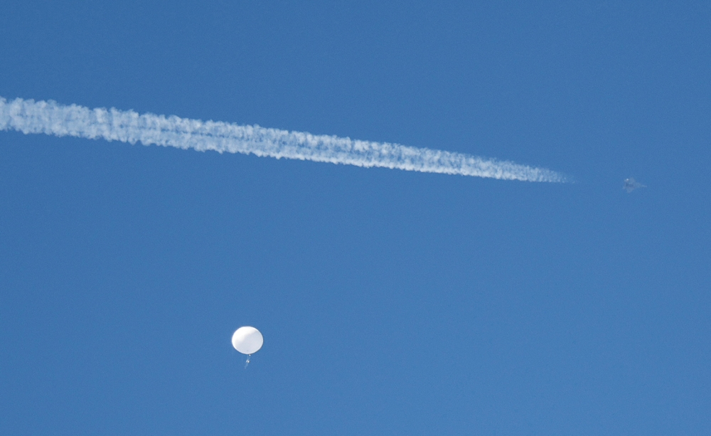 A jet flies by a suspected Chinese spy balloon as it floats off the coast in Surfside Beach, South Carolina February 4, 2023. — Reuters pic