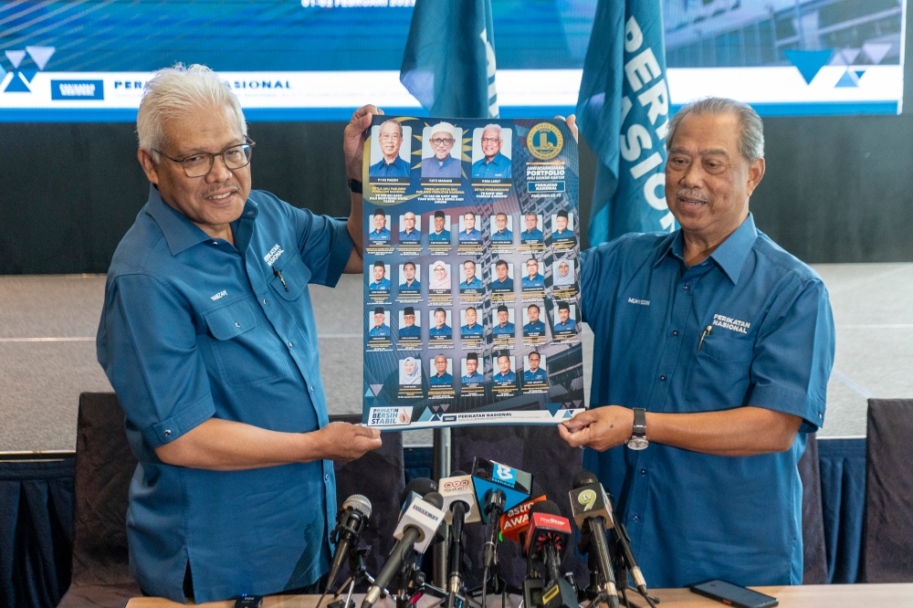 Perikatan Nasional chairman Tan Sri Muhyiddin Yassin holds up a poster of the party's shadow cabinet, 2 February 2023. — Picture by Shafwan Zaidon
