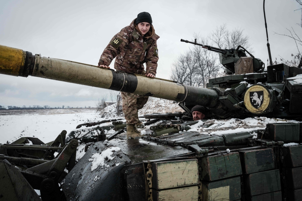 Ukrainian serviceman of the first tank brigade Igor (left), 26, who has worked as a gunner for four years, and the driver Volodymyr, 57, prepare to drive their T-64 Main Battle Tank near the frontline in the Donetsk region on February 4, 2023, amid the Russian invasion of Ukraine. — AFP pic