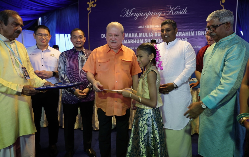 Sultan of Johor Sultan Ibrahim presenting a donation of RM200 to 10 selected students from a school in the Iskandar Puteri area during a dinner in conjunction with the Thaipusam celebration at the Arulmigu Sri Balasubramaniar Temple in Skudai, February 5, 2023. Also present are Johor Menteri Besar Datuk Onn Hafiz Ghazi and Johor State Health and Unity Committee Chairman Ling Tian Soon (left, back). — Bernama pic