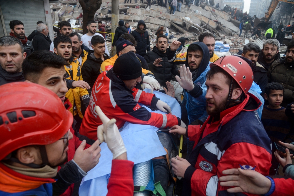 Rescue workers and volunteers pull out a survivor from the rubble in Diyarbakir February 6, 2023, after a 7.8-magnitude earthquake struck the country's south-east. — AFP pic
