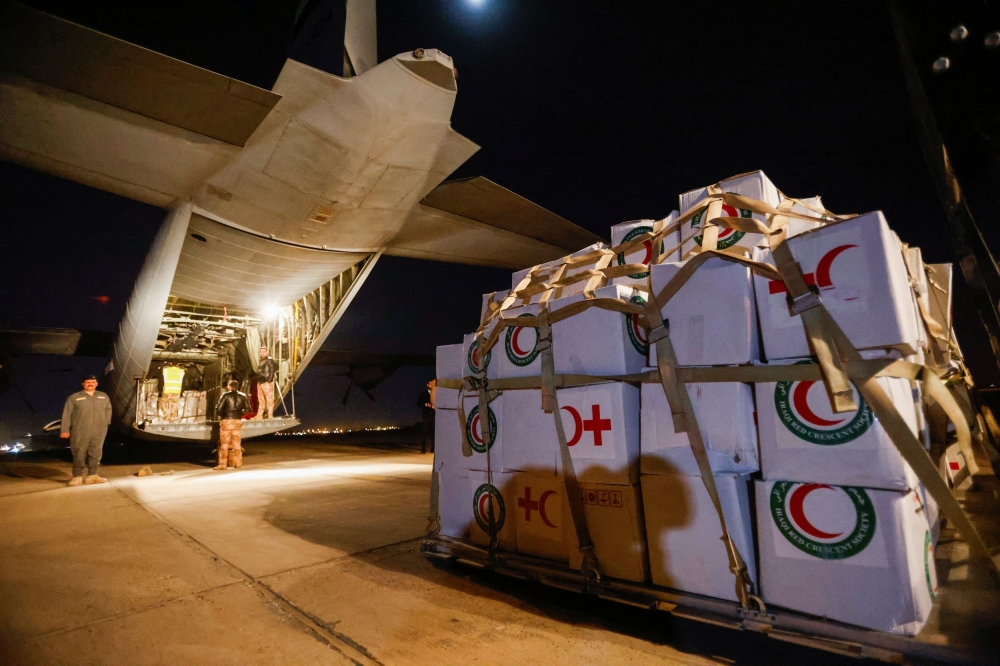Workers and security forces process aid from Red Crescent that will be shipped on a plane of emergency relief to Syria to support victims of the deadly earthquake, at a military airbase near Baghdad International Airport in Baghdad, Iraq February 6, 2023. ― Reuters pic