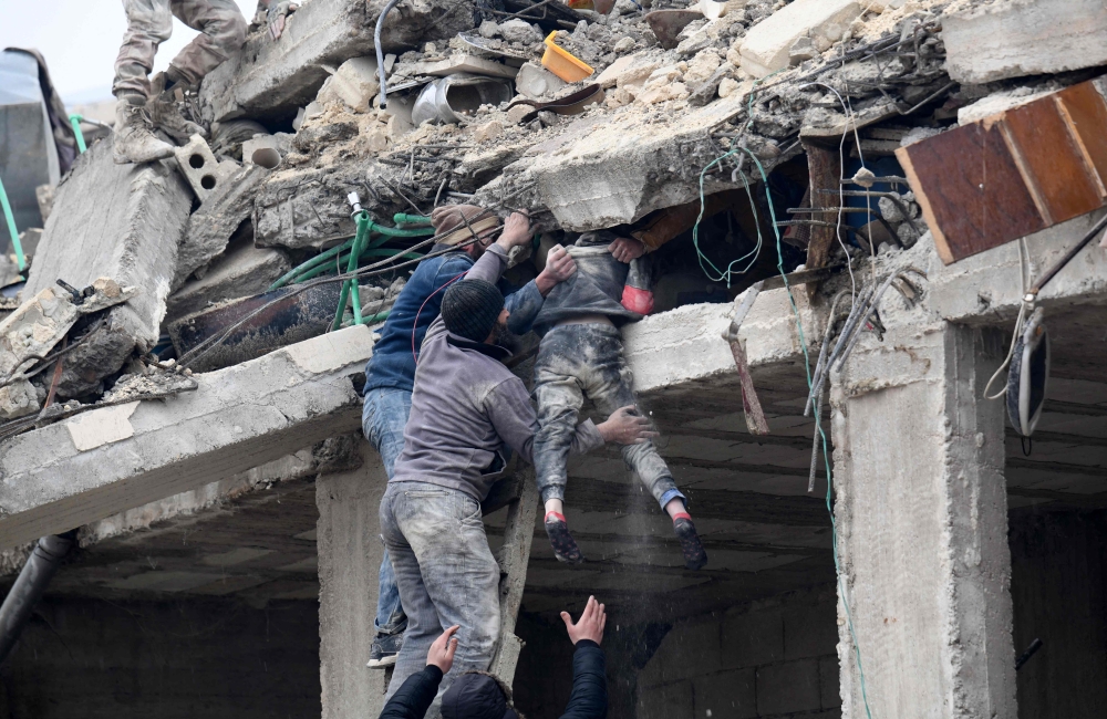 Residents retrieve an injured girl from the rubble of a collapsed building following an earthquake in the town of Jandaris, in the countryside of Syria’s northwestern city of Afrin in the rebel-held part of Aleppo province, on February 6, 2023. — AFP pic