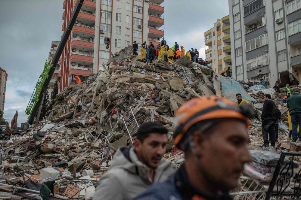 Rescuers search for victims and survivors amidst the rubble of a building that collapsed in Adana on February 6, 2023, after a 7.8-magnitude earthquake struck the country’s south-east. — Picture by Can EROK / AFP