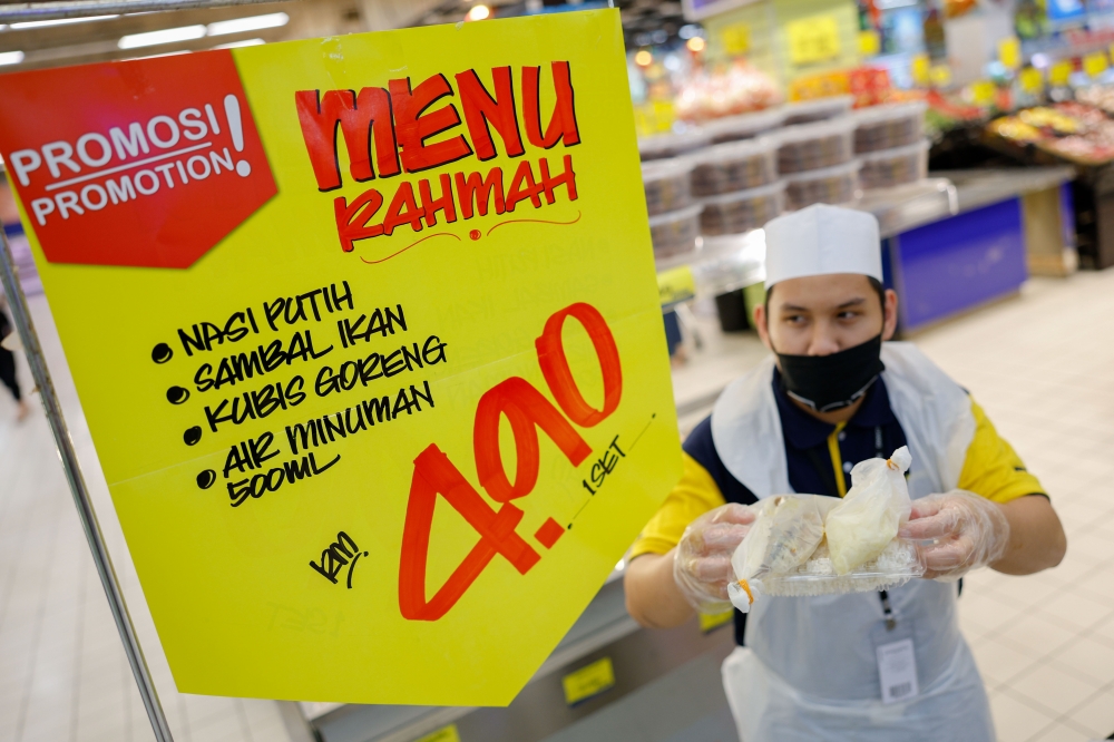 Worker Mohd Hafizuddin Abd Rahim, 19, shows a Menu Rahmah meal at the Mydin supermarket in Ayer Keroh, Melaka February 2, 2023. — Bernama pic