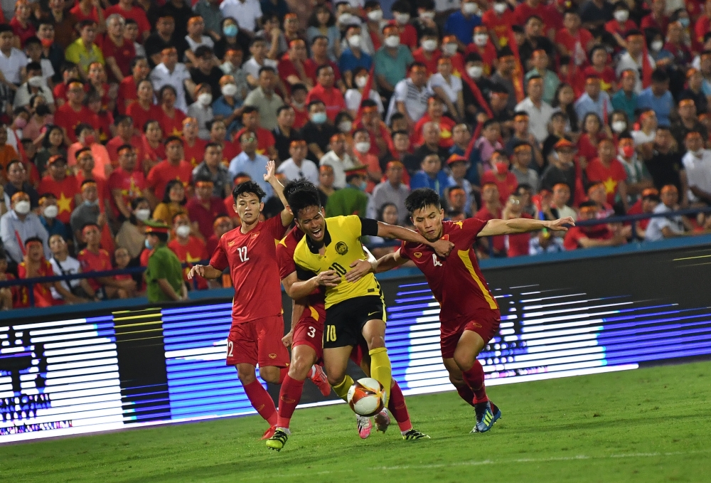 Malaysia’s Luqman Hakim Shamsudin (centre) was pushed by an opponent when playing against the Vietnamese team at the 2021 Sea Games at the Viet Tri Stadium, May 19, 2022. Malaysia lost 0-1 after the match was extended to extra time. — Bernama pic 