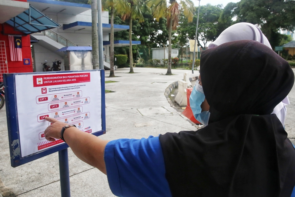 File picture of people looking at the free shuttle bus schedules to go home after work due to the closure of 16 Light Rail Transit (LRT) train stations between Kelana Jaya and Ampang Park at Taman Jaya LRT station November 10, 2022. — Picture by Choo Choy May