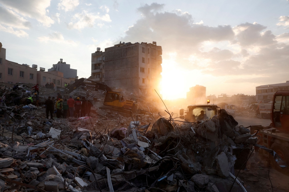 Members of a rescue team work on the site of a collapsed building, as the search for survivors continues, in the aftermath of a deadly earthquake, in Iskenderun, Turkey, February 11, 2023. — Reuters pic