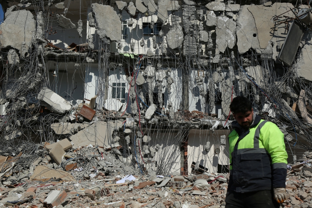 A rescuer walks past by a damaged building, in the aftermath of the deadly earthquake in Adiyaman, Turkey February 11, 2023. — Reuters pic