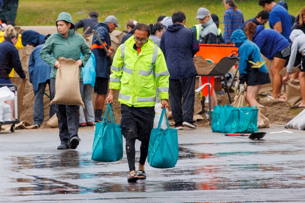 People fill up sandbags at a public collection point in preparation for the arrival of Cyclone Gabrielle in Auckland, New Zealand, February 12, 2023. —  AAP Image/David Rowland pic via Reuters