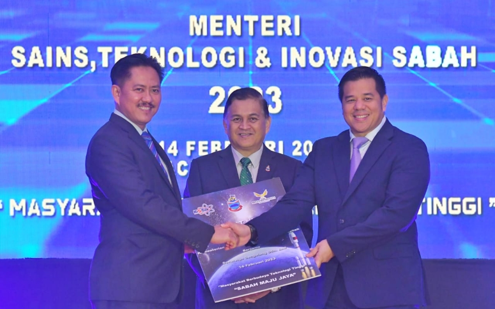 Sabah Science, Technology and Innovation Minister Datuk Arifin Arif (centre) looks on as the ministry's permanent secretary Datuk Zainudin Aman (left) shake hands with Sovereign Sengalang Sdn Bhd deputy executive chairman Ezra Effendi during a ceremony in Kota Kinabalu February 14, 2023 — Picture by Julia Chan
