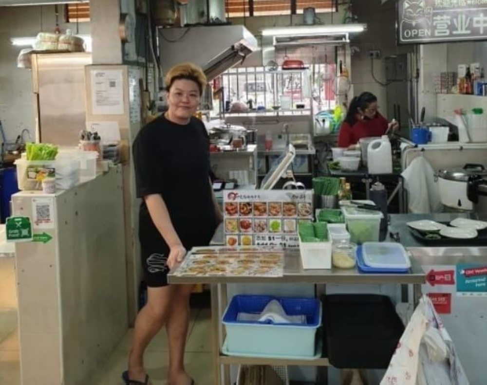 Singaporean hawker Jalynn Woon returns RM42,000 left behind by a customer in front of her stall. — Picture via Facebook/ Good for you Singapore  
