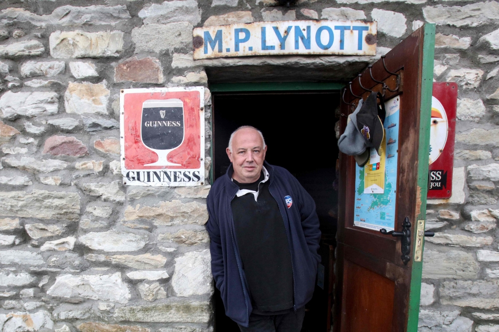Owner of the Lynotts pub Mick Lynch, poses for a photograph outside of his pub on the Achill island, on January 31, 2023, on the Purteen harbour. — AFP pic