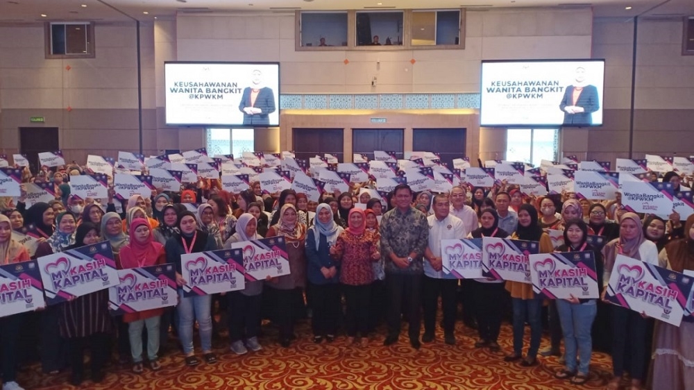 Datuk Seri Nancy Shukri (centre) with Deputy Minister for Utilities and Communications Datuk Abdul Rahman Junaidi on her left in a group photo with women participants and entrepreneurs at ‘Bangkit@KPWKM MyKasih Kapital’ programme. — Borneo Post pic