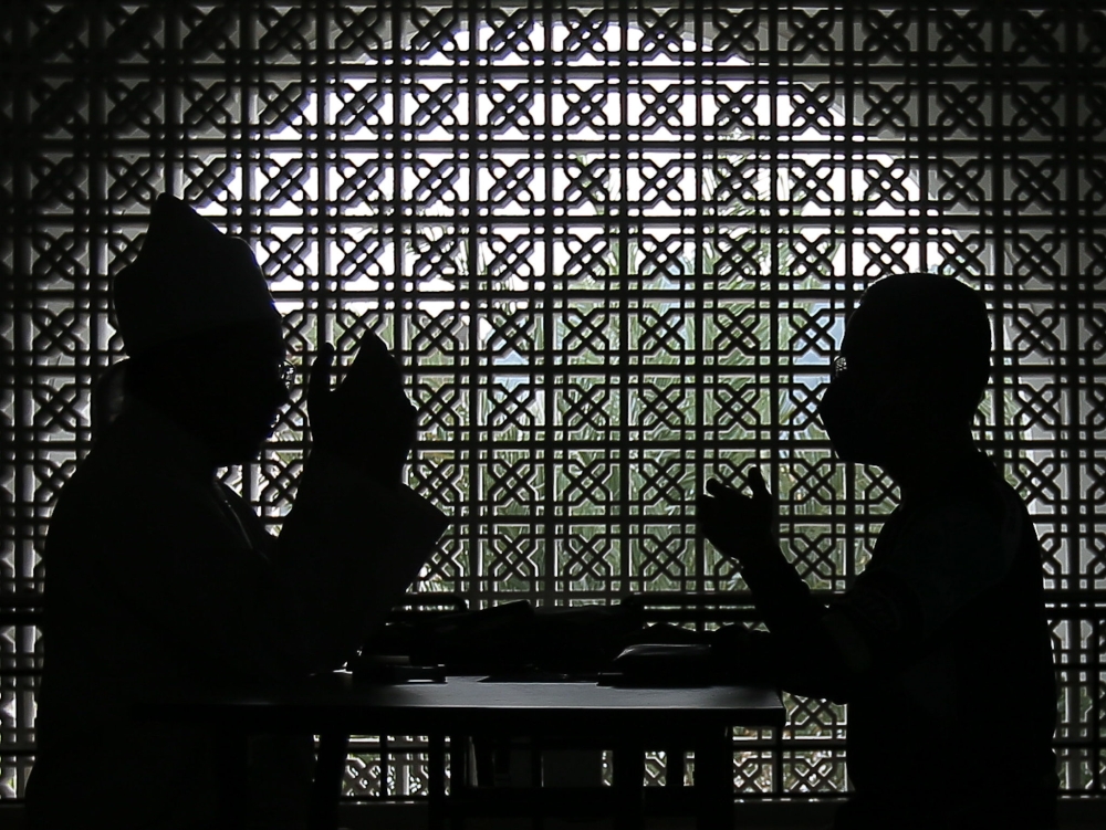 File picture of a man paying zakat at a mosque in Perak. — Picture by Farhan Najib