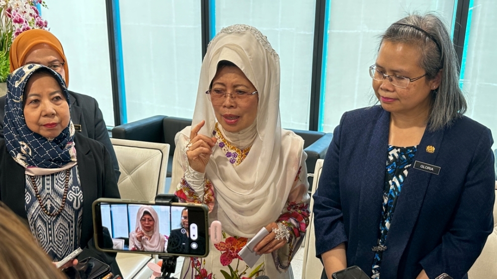 Fatimah (centre) speaks to reporters as Deputy Women, Childhood and Community Wellbeing Development Minister Datuk Rosey Yunus (left) and Gloria (right) look on. — Picture by Muhammad Rais Sanusi/Borneo Post