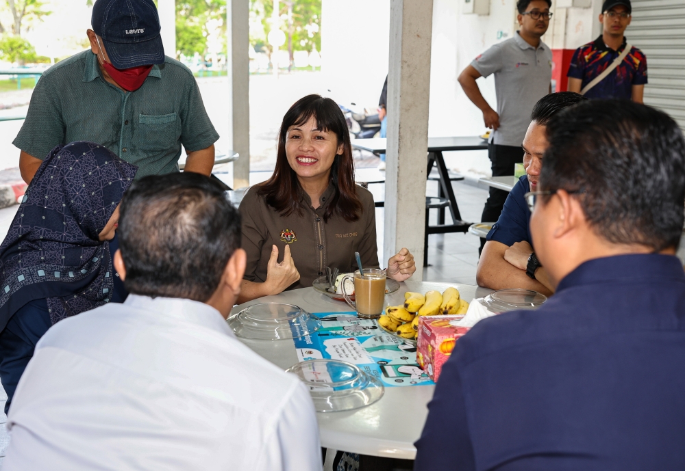 Deputy Communications and Digital Minister Teo Nie Ching (centre) has breakfast during a walkabout at Perak Stadium food court in Ipoh February 26, 2023. — Bernama pic