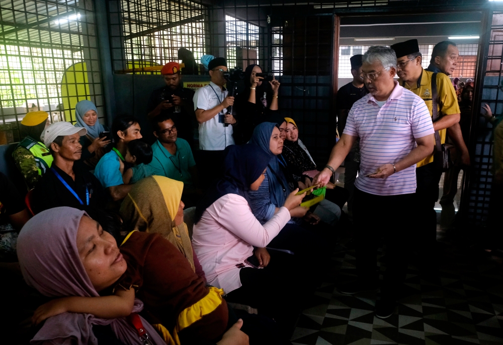 Yang di-Pertuan Agong Al-Sultan Abdullah Ri'ayatuddin Al-Mustafa Billah Shah presenting donations to flood victims at the Kampung Baru Sungai Chedong temporary relief centre today. ― Bernama pic