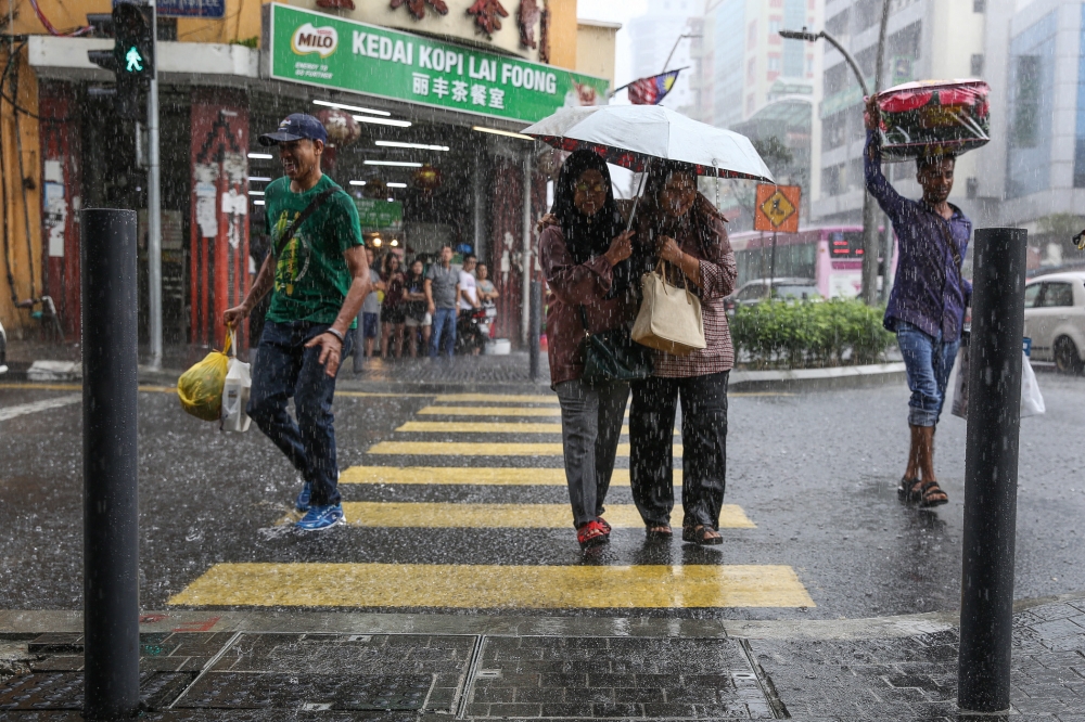 File picture of pedestrians walking in the rain in Kuala Lumpur. Johor recorded the highest rainfall for the period beginning February 28 until yesterday compared with the highest monthly rainfall records in December 1991 and December 2006. — Picture by Yusof Mat Isa