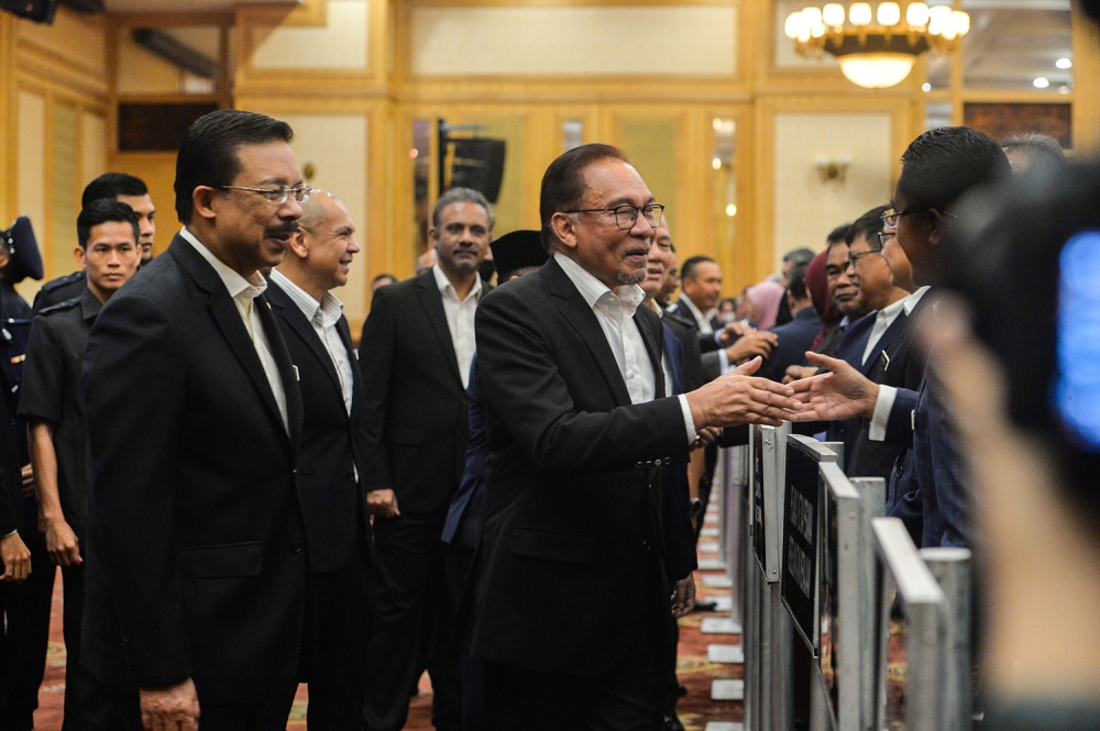 Prime Minister Datuk Seri Anwar Ibrahim greets civil servants as he attends the Prime Minister's Department monthly assembly in Putrajaya March 6,2023. — Picture by Miera Zulyana
