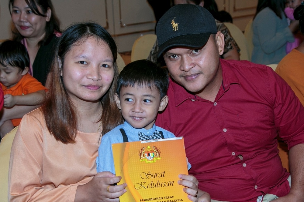 Elda and Edger with their son Abell after receiving his citizenship approval letter.  — Borneo Post Online pic