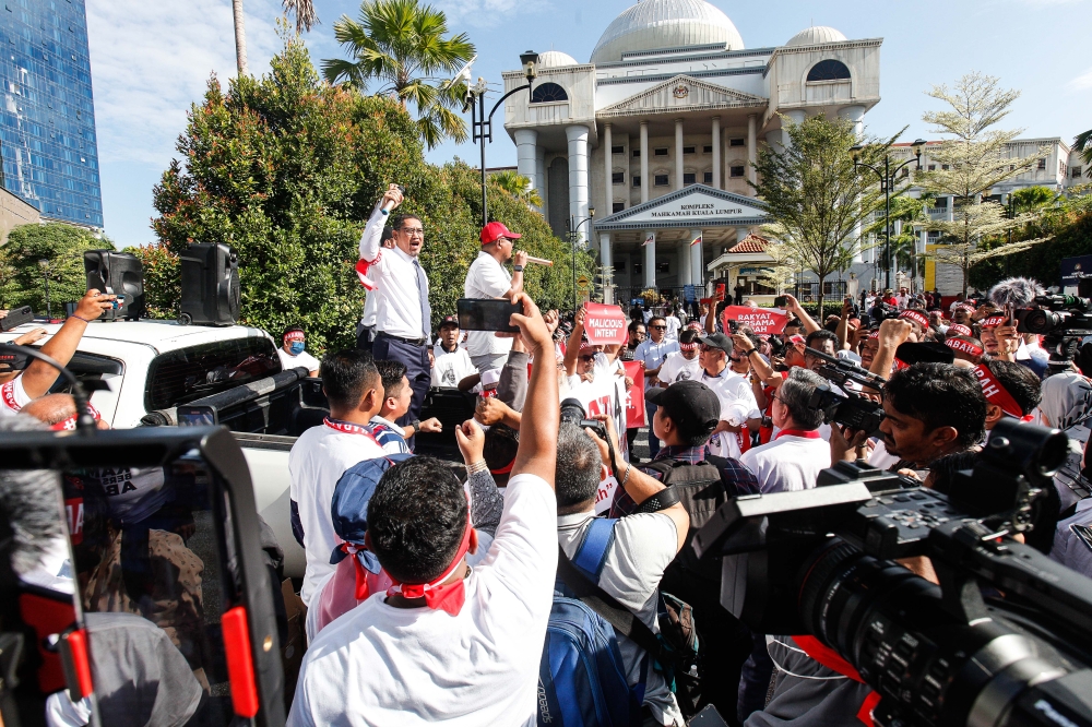 Supporters brace the blazing heat as they wait for Perikatan Nasional chairman Tan Sri Muhyiddin Yassin outside the Kuala Lumpur Court Complex March 10, 2023. — Picture by Sayuti Zainudin