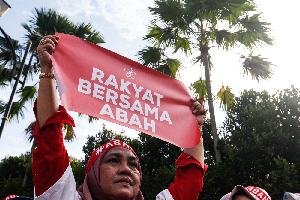 A supporter of Tan Sri Muhyiddin Yassin holds up a banner outside the Kuala Lumpur Court Complex March 10, 2023. — Picture by Sayuti Zainudin
