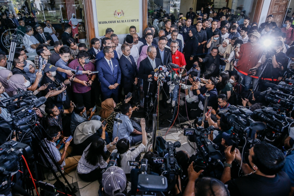 Former prime minister Tan Sri Muhyiddin Yassin (centre) speaks to the press outside the Kuala Lumpur High Court Complex March 10, 2023. — Picture by Hari Anggara
