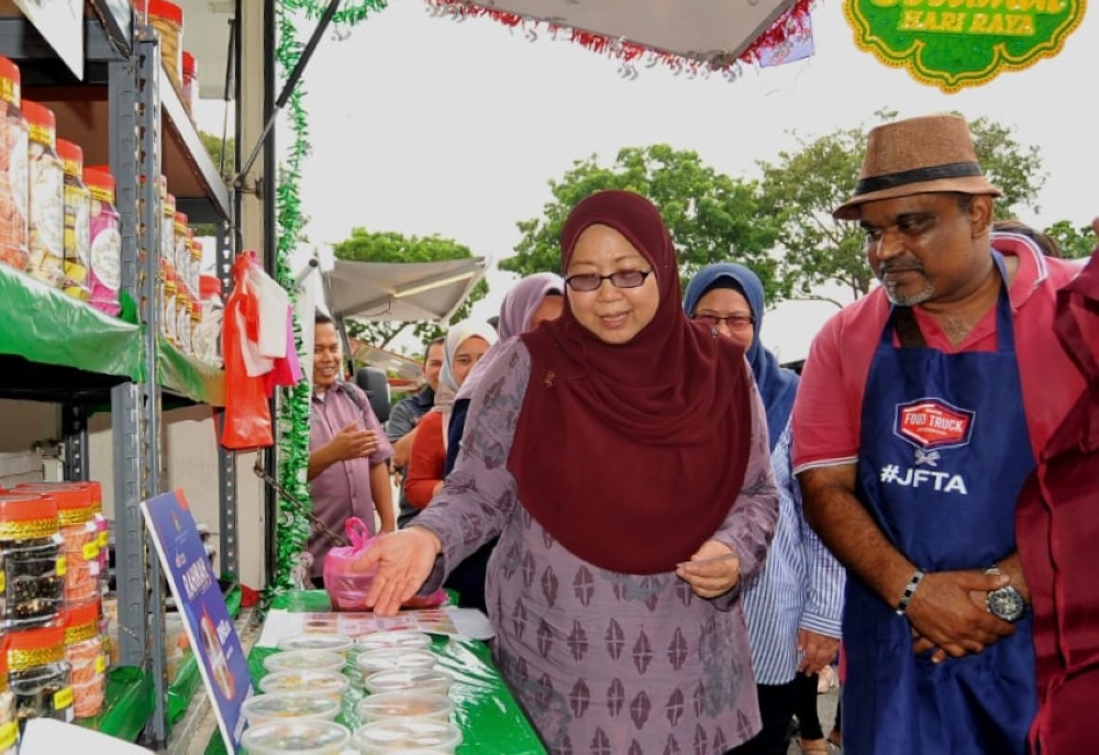 Domestic Trade and Cost of Living Deputy Minister Fuziah Salleh (left) visits a food truck operator after officiating the Rahmah Kasih Sayang Food Truck Fiesta in Johor Baru March 10, 2023. — Picture by Ben Tan