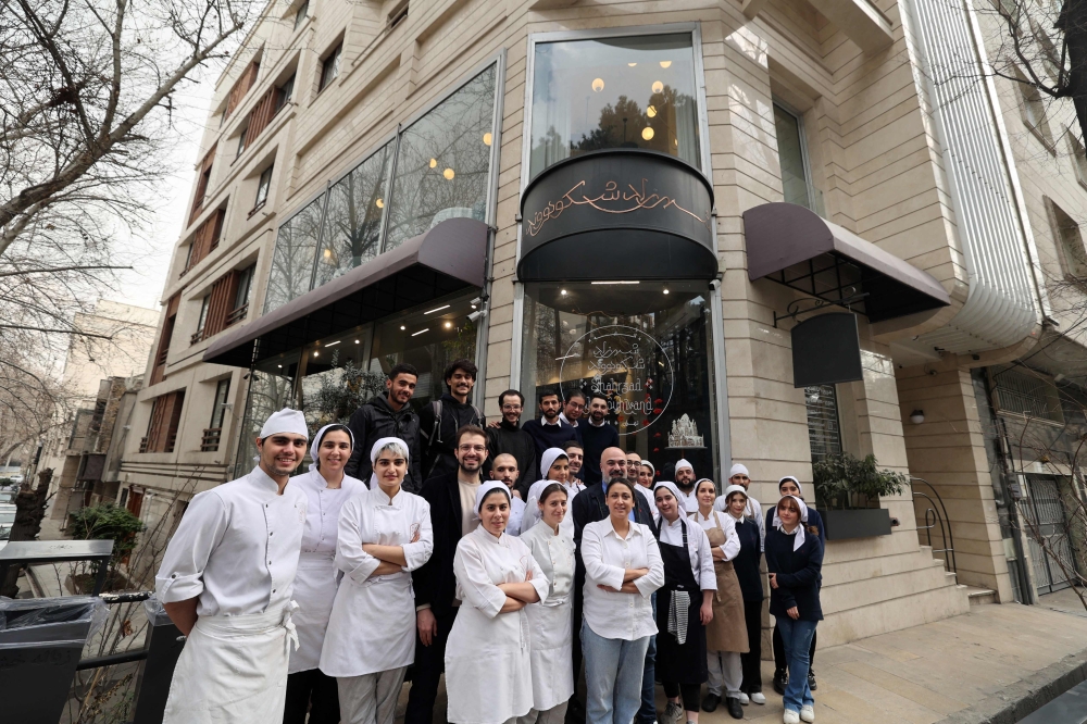 Iranian pastry chef Shahrzad Shokouhivand, poses for a picture with members of her team in front of her luxury pastry shop in Tehran, on February 26, 2023. — AFP pic