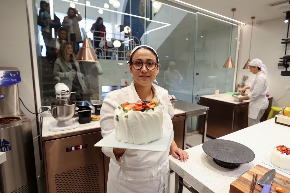 Iranian pastry chef Shahrzad Shokouhivand, poses for a picture with a cake in the kitchen of her luxury pastry shop in Tehran, on February 26, 2023. — AFP pic