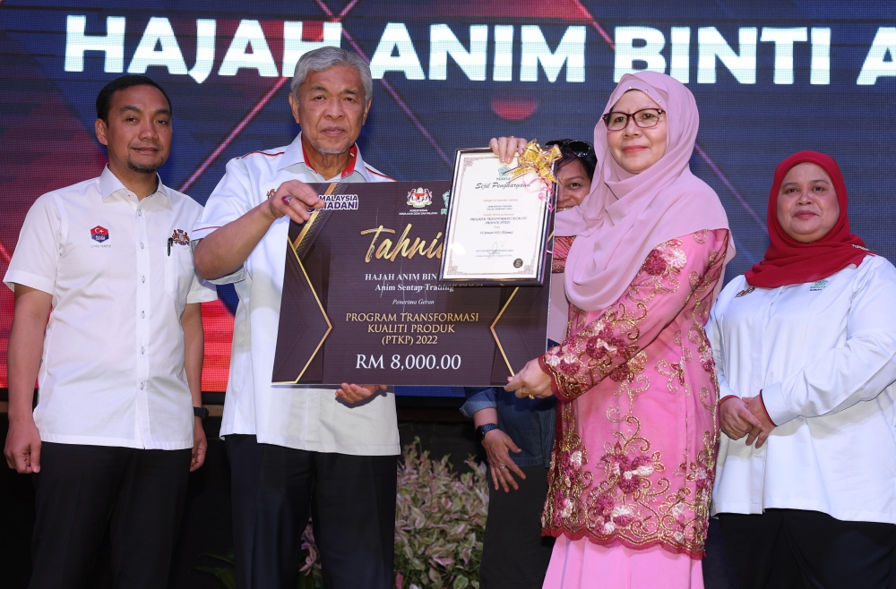Deputy Prime Minister Datuk Seri Ahmad Zahid Hamidi presents cash and a certificate to Anim Abu (2nd right) during a working visit to the South-east Johor Development Board (Kejora) at the Kejora headquarters, Bandar Penawar, Kota Tinggi March 12, 2023. — Bernama pic