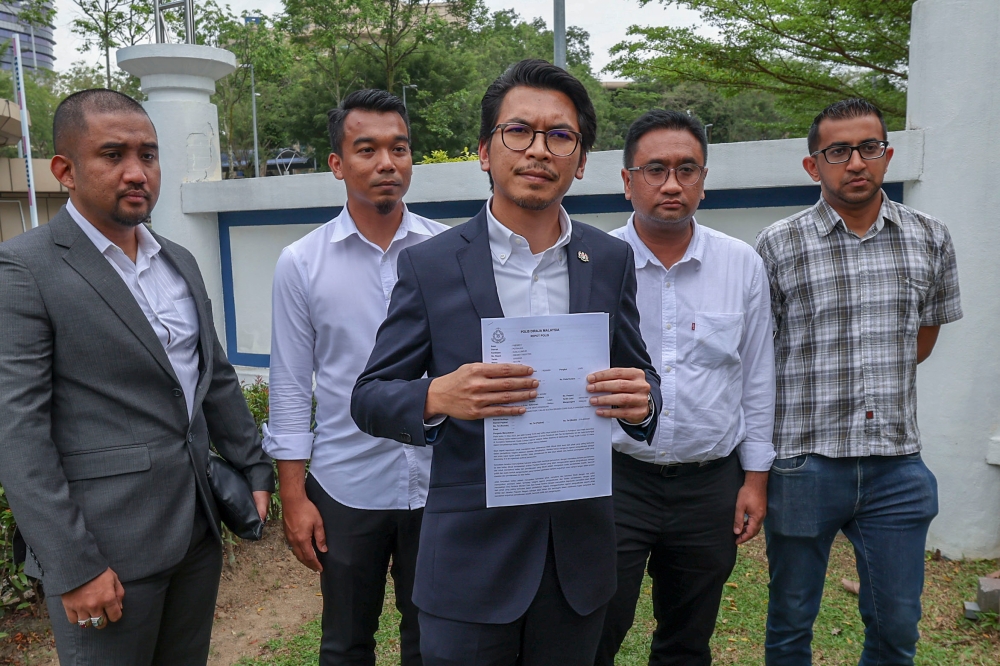 Political Secretary to the Minister of Finance, Muhammad Kamil Abdul Munim showing the police report he made at the Putrajaya District Police Headquarters March 13, 2023. — Bernama pic