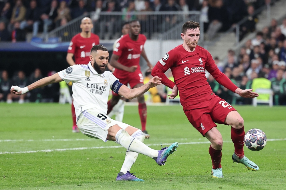 Real Madrid's French forward Karim Benzema kicks the ball next to Liverpool's Scottish defender Andrew Robertson during the Uefa Champions League last 16 second leg football match between Real Madrid CF and Liverpool FC at the Santiago Bernabeu stadium in Madrid on March 15, 2023. — AFP pic