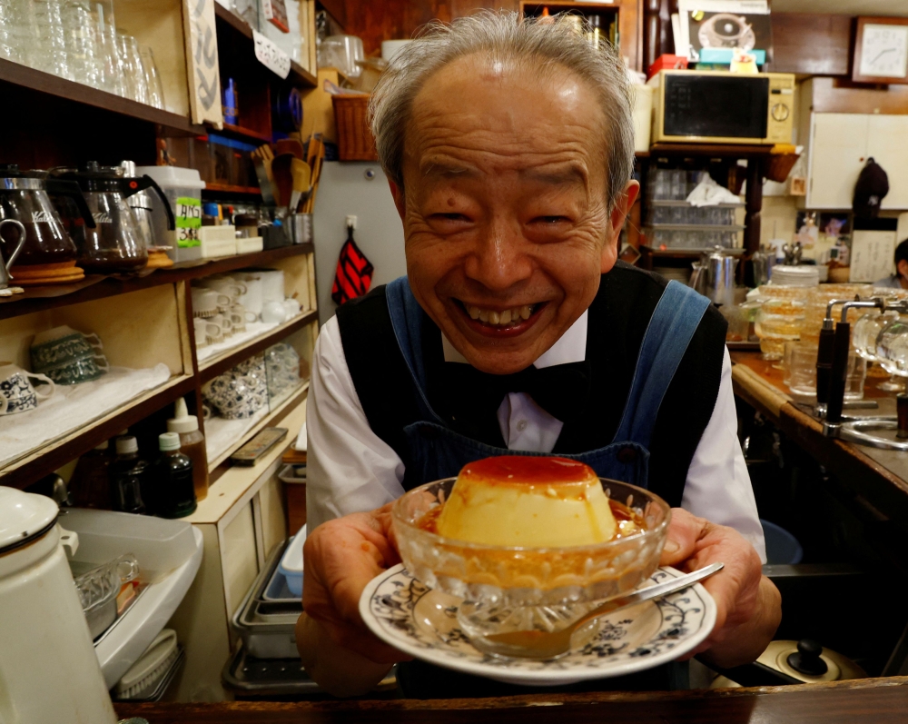 Shizuo Mori poses with a pudding during a photo opportunity at his Heckeln coffee shop in Tokyo, Japan March 15, 2023. — Reuters pic