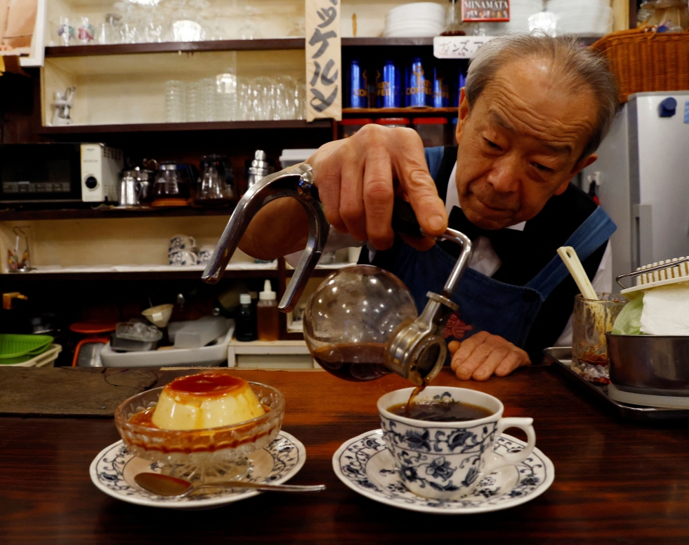 Shizuo Mori serves a pudding and a cup of coffee. — Reuters pic