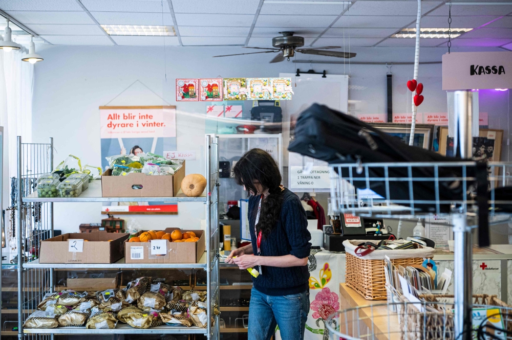 A woman is seen preparing donated food items from local supermarkets to be sold at reduced prices in a Red Cross branch on March 14, 2023, in Stockholm March 14, 2023. — AFP pic